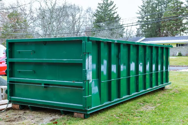 Tall 30-yard class roll-off dumpster set on boards for a yard project