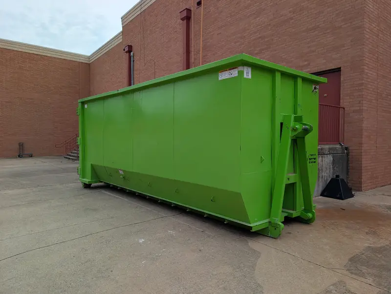 Large high-wall roll-off dumpster behind a commercial building